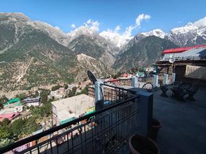 a balcony with a view of a mountain range at Hotel Cafeteria Roof in Kalpa
