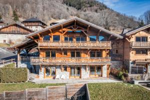 an exterior view of a log home with a mountain at Heavenly, Montriond, luxe, 8-12 personnes in Montriond