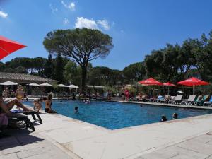 a swimming pool with people sitting in chairs and umbrellas at Douce Provence - Provence Cote d'Azur in Vidauban