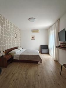 ein Schlafzimmer mit einem Bett und einem Flachbildfernseher in der Unterkunft Apartments Miljas in Cavtat