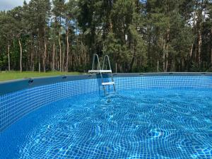 a swimming pool with a chair in the water at Dom pod Niebem in Lucimia