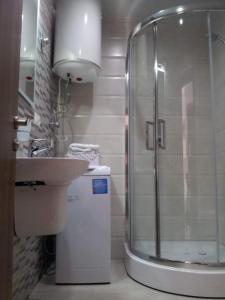 a bathroom with a shower and a sink and a toilet at Batumi Seaside Apartments in Angisa