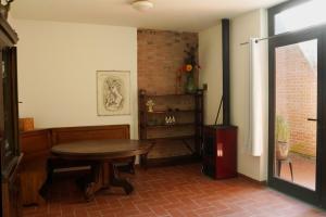 a dining room with a table and a brick wall at La stamberga nel bosco in Asciano Pisano