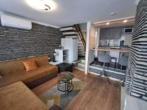 a living room with a couch and a kitchen at Panoramic house in Szigliget in Szigliget