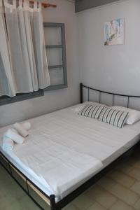 a bed with white sheets and pillows in a bedroom at LaCasa Garden in Skiathos +16 photos
