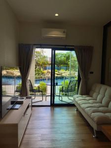 Una sala de estar con un sofá y una puerta corrediza de vidrio. en JU3 Halo NEW ВатСaп66935B2I976, en Nai Yang Beach