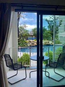 Un balcón con dos sillas y una mesa con vista. en JU3 Halo NEW ВатСaп66935B2I976, en Nai Yang Beach