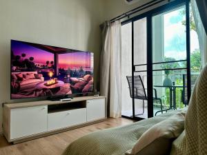 sala de estar con TV de pantalla plana en una habitación en JU3 Halo NEW ВатСaп66935B2I976, en Nai Yang Beach