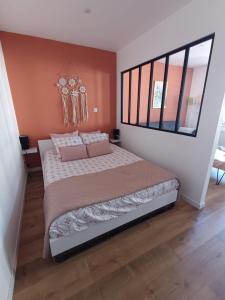a bedroom with a large bed with pink pillows at Appartement cosy à Chamagne in Chamagne