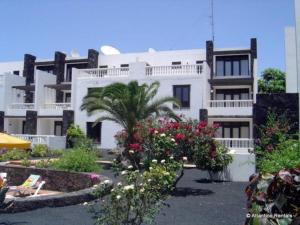 a large white building with flowers in front of it at B17 Caleton blanco in Tías