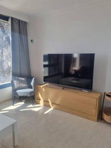 a living room with a flat screen tv and a chair at B16 caleton blanco in Puerto del Carmen