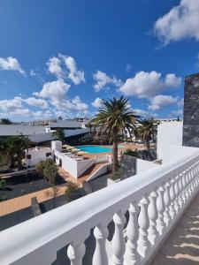 a balcony with a white railing and a swimming pool at B16 caleton blanco in Puerto del Carmen