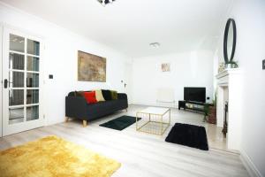 a living room with a couch and a tv at Milestone House By N And N Stays, Contractor Friendly, 6 Bed house, Sleeps 10, Private Parking, WIFI in Cardiff