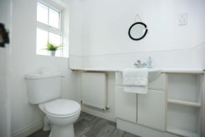 a white bathroom with a toilet and a sink at Milestone House By N And N Stays, Contractor Friendly, 6 Bed house, Sleeps 10, Private Parking, WIFI in Cardiff