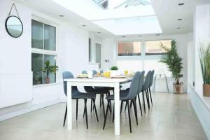 a white dining room with a white table and chairs at Milestone House By N And N Stays, Contractor Friendly, 6 Bed house, Sleeps 10, Private Parking, WIFI in Cardiff +19 photos