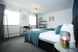 a bedroom with a bed and a table with a lamp at Milestone House By N And N Stays, Contractor Friendly, 6 Bed house, Sleeps 10, Private Parking, WIFI in Cardiff