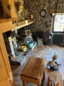 a living room with a stone fireplace and a table at Maison avec balcon à Borne, 70 m², 5 personnes avec jardin in Mayres