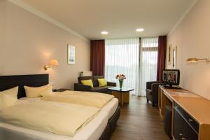 ein Hotelzimmer mit einem Bett und einem Sofa in der Unterkunft Garni Hotel & Ferienwohnungen Seeschlößchen in Waldeck