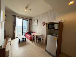 a small living room with a red couch and a table at Condo Sea view Beach U25 in Pattaya South