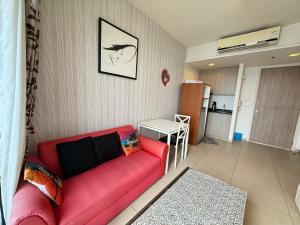 a living room with a red couch and a kitchen at Condo Sea view Beach U25 in Pattaya South