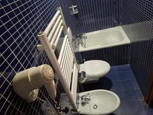 a blue tiled bathroom with a sink and a toilet at Beauty Rooms in Rome