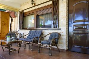 a group of chairs and a table on a porch at Sani Villa Elmira in Sani Beach