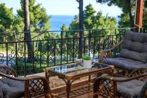 a patio with two chairs and a table on a balcony at Sani Villa Elmira in Sani Beach