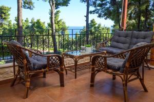 a patio with two chairs and a table on a balcony at Sani Villa Elmira in Sani Beach +33 photos