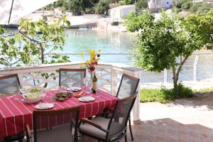 a table with a red table cloth on a patio with a pool at Kuća Ugor in Lun
