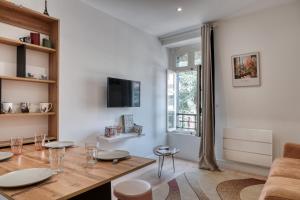 een woonkamer met een eettafel en een tv bij L'Atelier Parisien - Proche Gare & Disneyland in Lagny