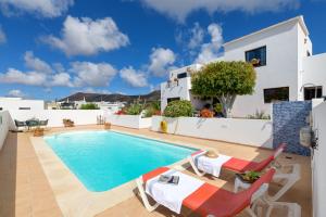 una villa con piscina y una casa en Elvira, en Tías