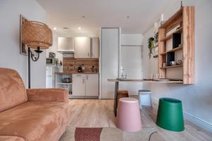 een woonkamer met een bank en een tafel bij L'Atelier Parisien - Proche Gare & Disneyland in Lagny