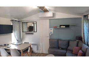 a living room with a couch and a table at Mobil-home -Clim, TV, LV- Camping LE LAC DES RÊVES 4 étoiles - MH-A009 in Lattes
