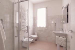 a white bathroom with a toilet and a sink at Alessia in wonderland in Alghero