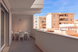 a balcony with a table and chairs and buildings at Alessia in wonderland in Alghero