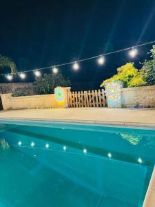a swimming pool at night with a fence and lights at Tenuta del salento in Galatina