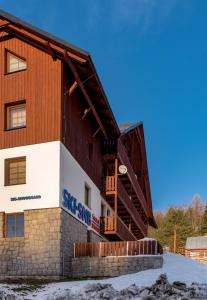 a large wooden building with snow on the ground at Apartmán Albrechtice in Albrechtice v Jizerských horách +20 photos