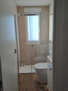 un bagno con doccia, WC e finestra di Atico con vistas a la Ría a A Pobra do Caramiñal Altre 15 foto