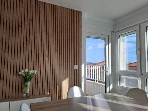 una sala da pranzo con tavolo, sedie e una finestra di Atico con vistas a la Ría a A Pobra do Caramiñal