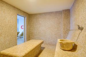 a bathroom with a tub in the corner of a room at Greenwood Hotel Restaurant & Spa in Batumi