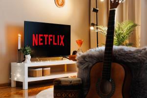 a guitar sitting in a chair in a living room with a tv at Harmonic Nest 3min to Republic Square Renovated in Belgrade +41 photos