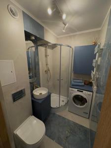 a bathroom with a toilet and a washing machine at Apartament Słowackiego Sopot in Sopot +6 photos