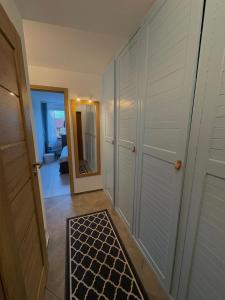 a hallway with white doors and a black and white rug at Apartament Słowackiego Sopot in Sopot