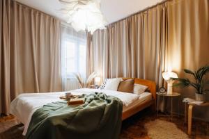 a bedroom with a bed and a window with curtains at Harmonic Nest 3min to Republic Square Renovated in Belgrade