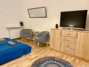 a living room with a flat screen tv on a dresser at Topolove Rooms & Apartments in Krakow