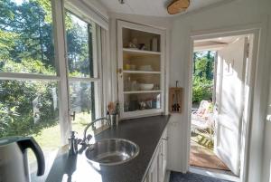 a kitchen with a sink and a large window at Onder de Paddn in Wapenveld