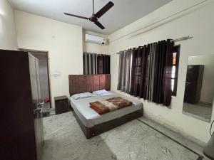 デヘラードゥーンにあるShree Ji Home Stay Peaceful & Comfortable Rooms in Dehradunのベッドと天井扇風機のある寝室