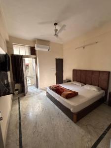 デヘラードゥーンにあるShree Ji Home Stay Peaceful & Comfortable Rooms in Dehradunの大きなベッドとテレビのある寝室
