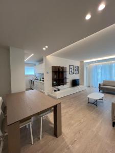 a living room with a table and a couch at Monaco Apartments in Lignano Sabbiadoro