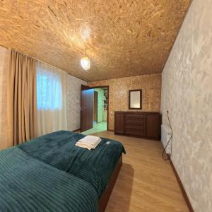 a bedroom with a green bed and a wooden floor at Apartment Gira In Mestia in Mestia